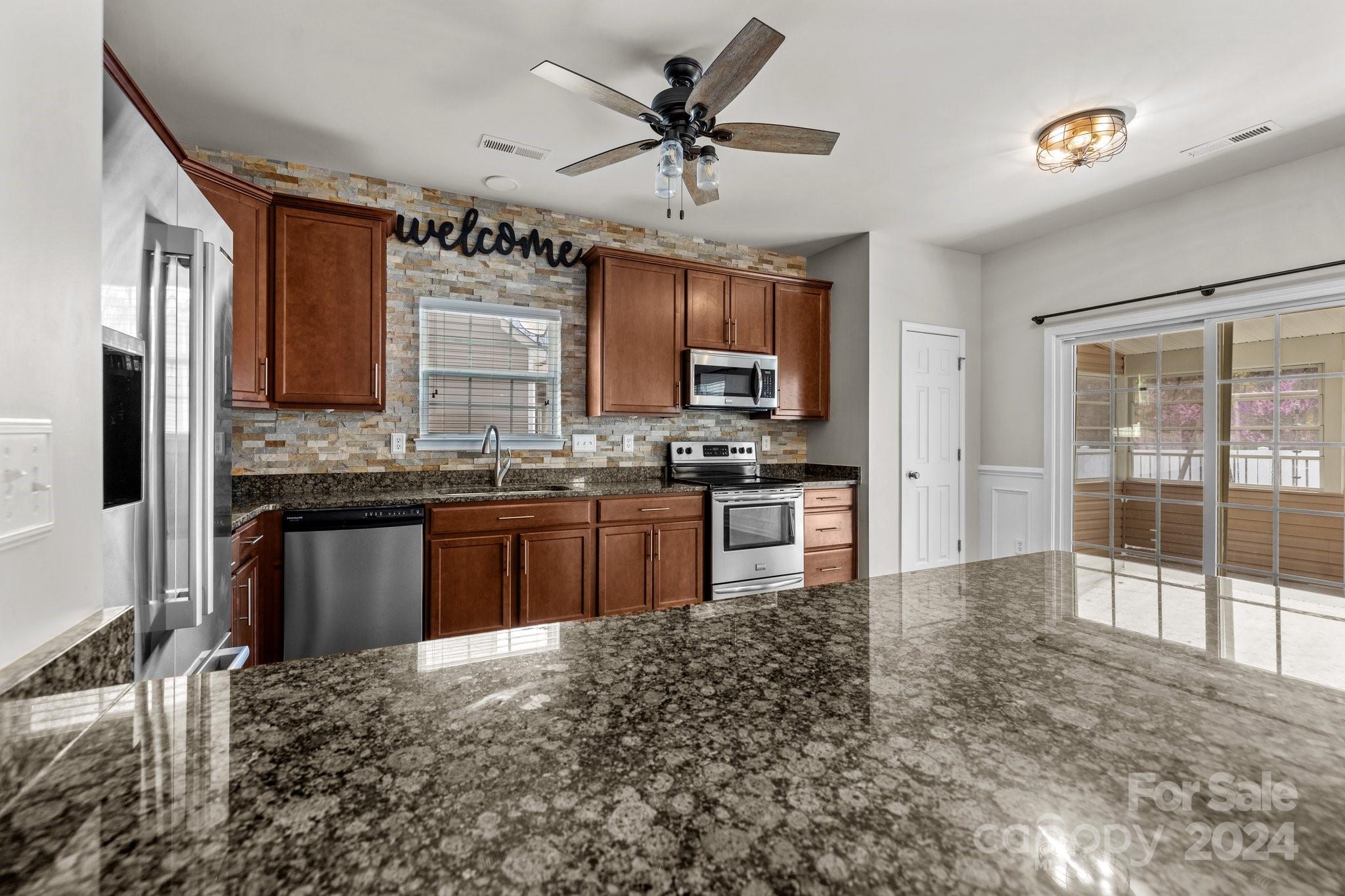 1653 Beleek Ridge Lane Clover, SC 29710 - Photo 11 of 46 a kitchen with stainless steel appliances kitchen island granite countertop a stove sink and cabinets