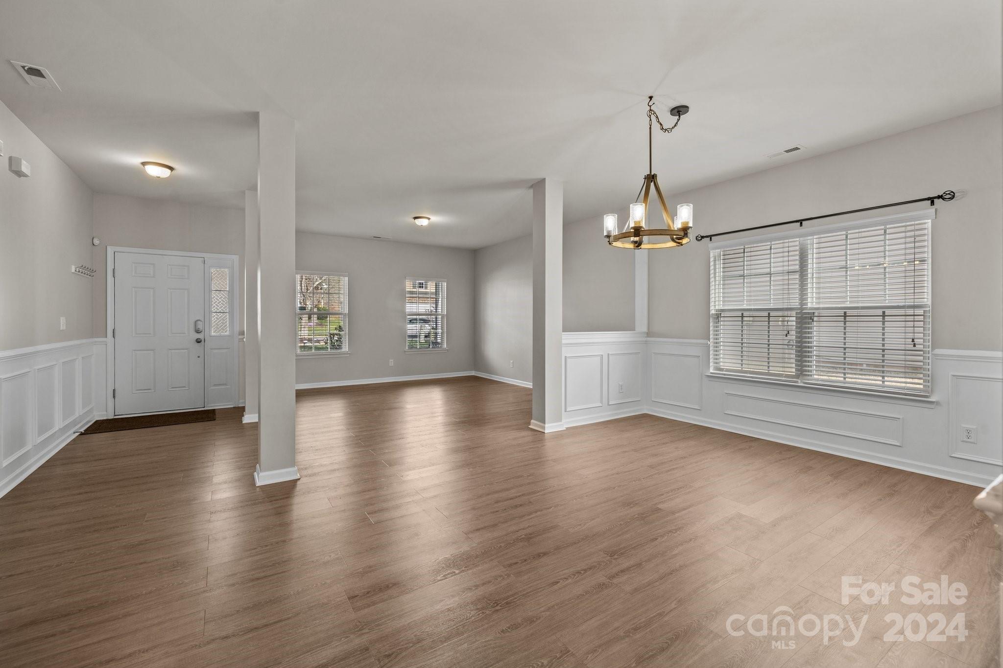 1653 Beleek Ridge Lane Clover, SC 29710 - Photo 9 of 46 an empty room with wooden floor chandelier and windows