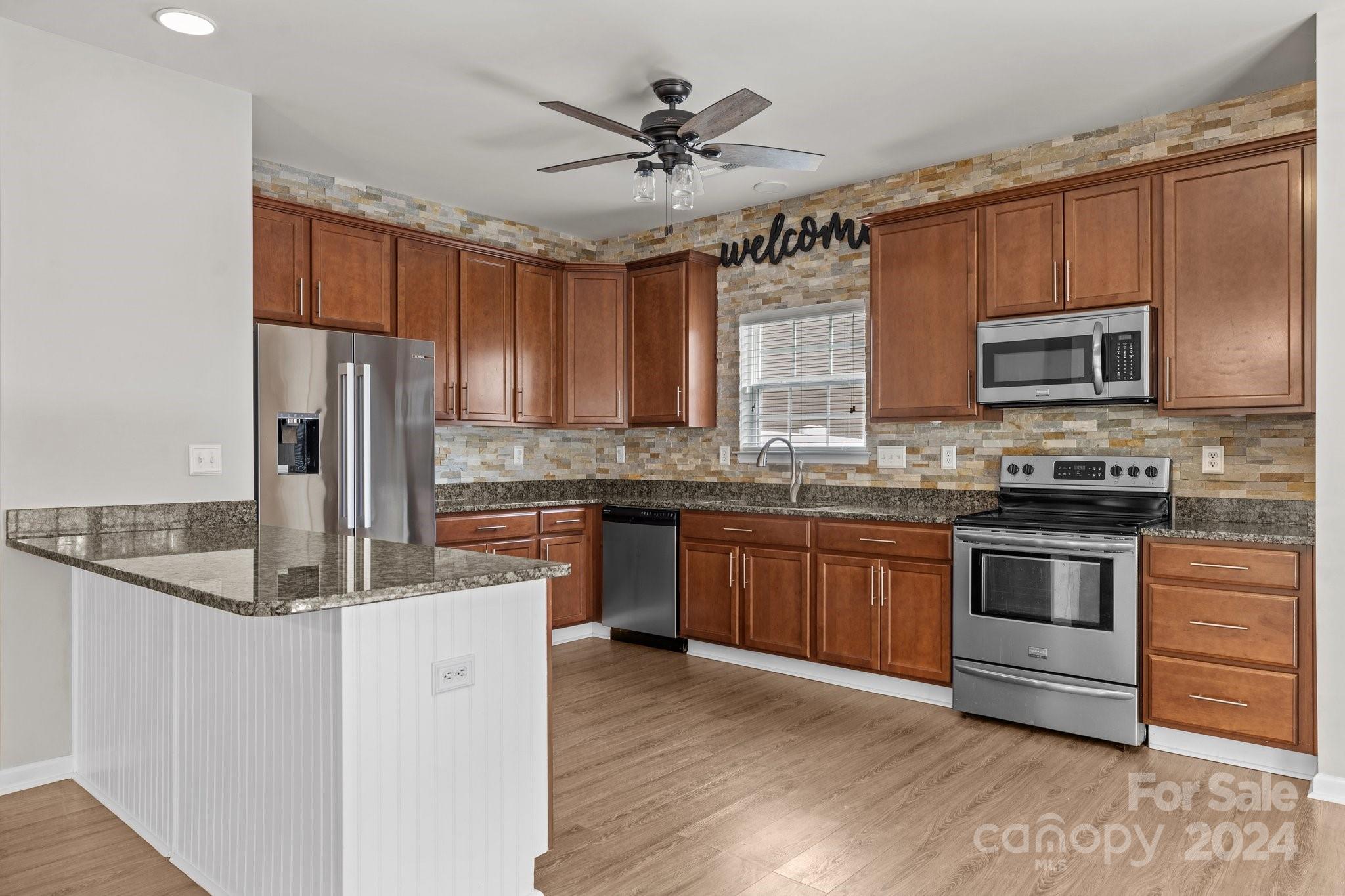 1653 Beleek Ridge Lane Clover, SC 29710 - Photo 10 of 46 a kitchen with kitchen island granite countertop a stove cabinets and refrigerator