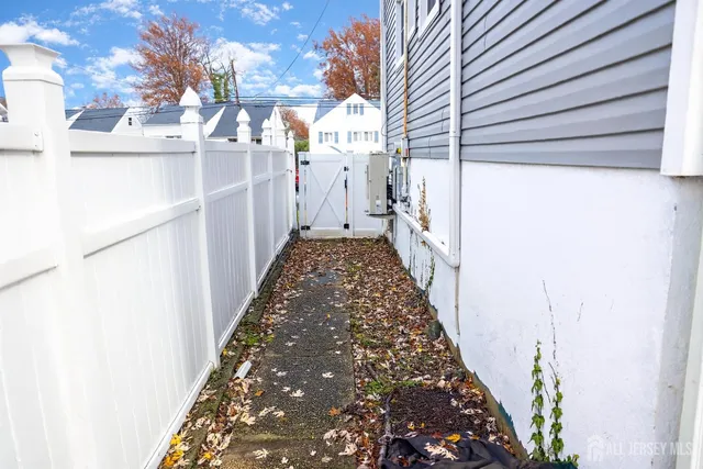 a view of a pathway of a house with wooden fence