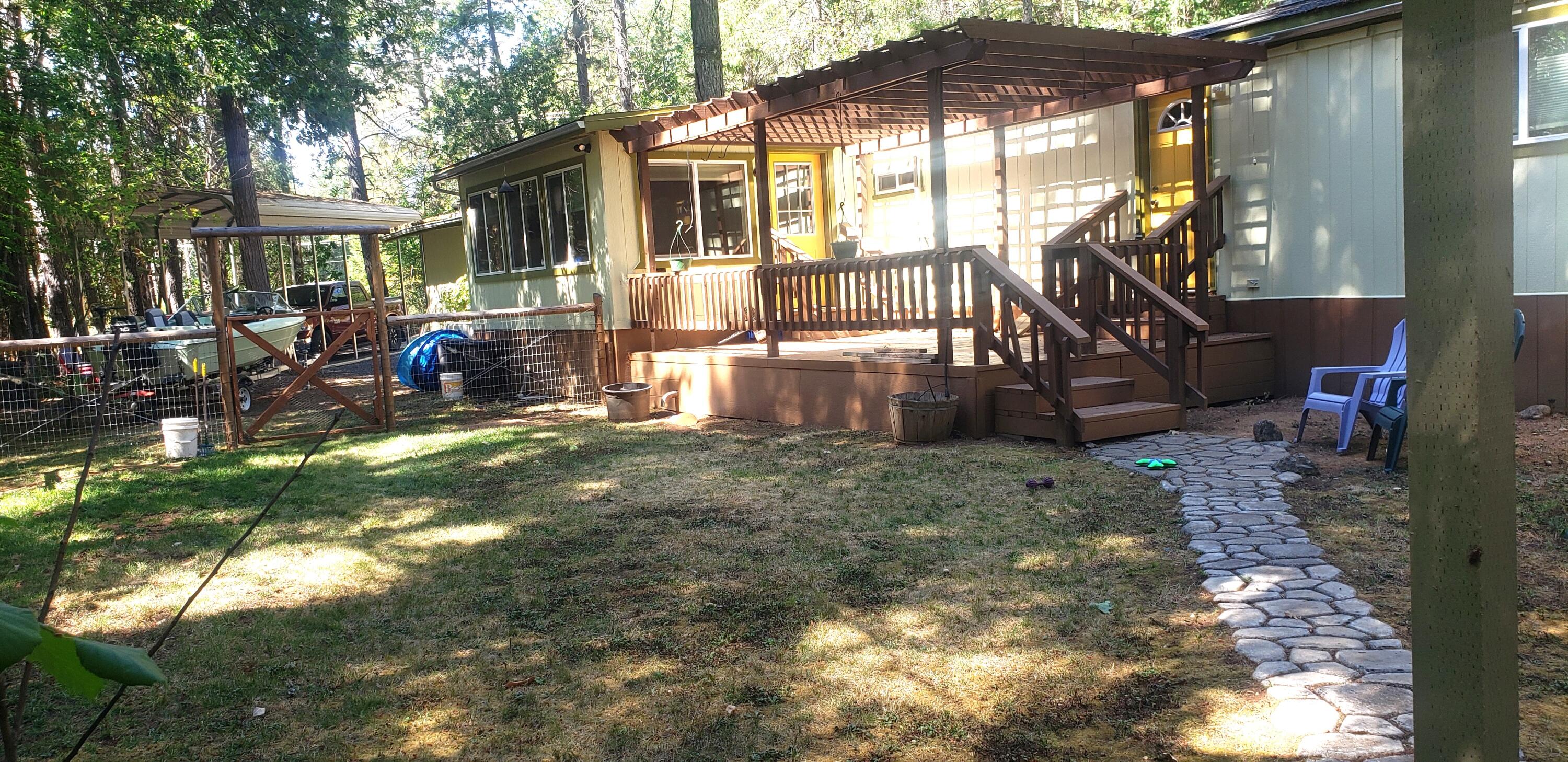 393 North Old Stage Road Cave Junction, OR 97523 - Photo 15 of 21 Back of home with deck, pavers lead to storage shed.