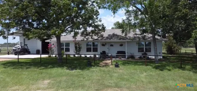 a front view of a house with a garden and trees