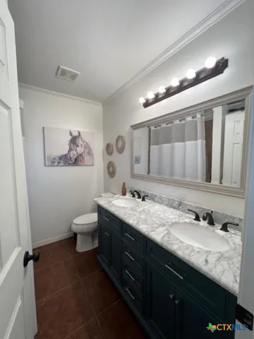 a bathroom with a granite countertop sink mirror and toilet