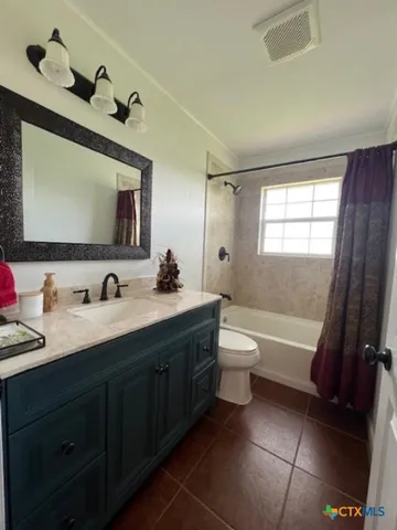 a bathroom with a granite countertop sink toilet a large mirror and bathtub