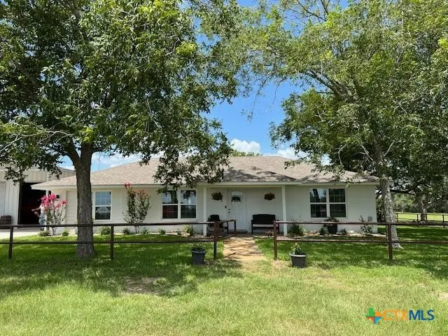 a view of a white house with a big yard and a large tree