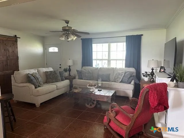 a living room with furniture a flat screen tv and a window