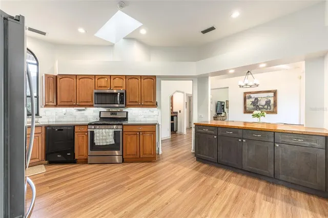 a large kitchen with wooden floors and stainless steel appliances