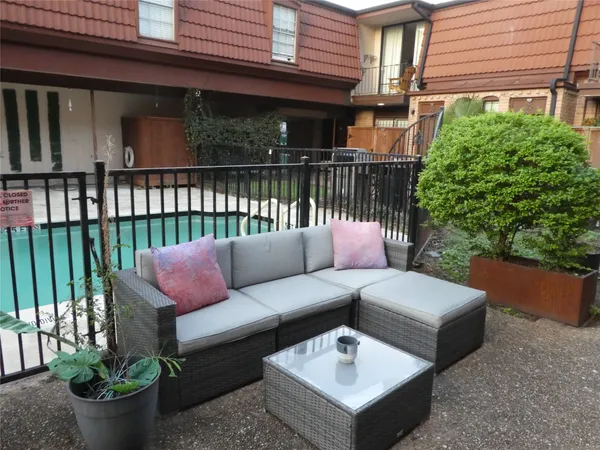 a view of a patio with couches table and chairs and potted plants