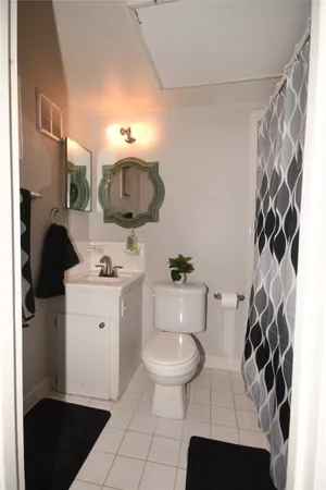 a bathroom with a toilet sink vanity granite and shower