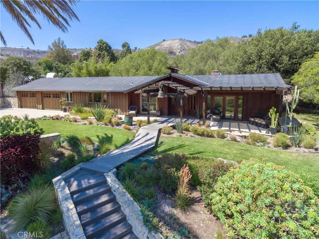 a front view of a house with garden and sitting area