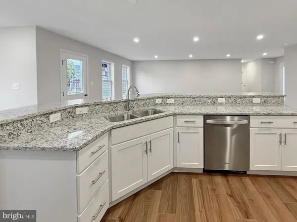 a kitchen with granite countertop white cabinets and white appliances