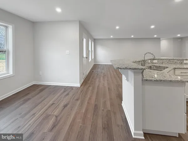 a view of a kitchen with a sink and wooden floor