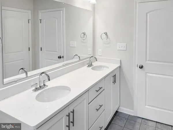 a bathroom with double sink and a mirror