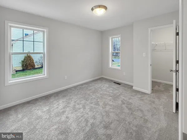 an empty room with windows and closet