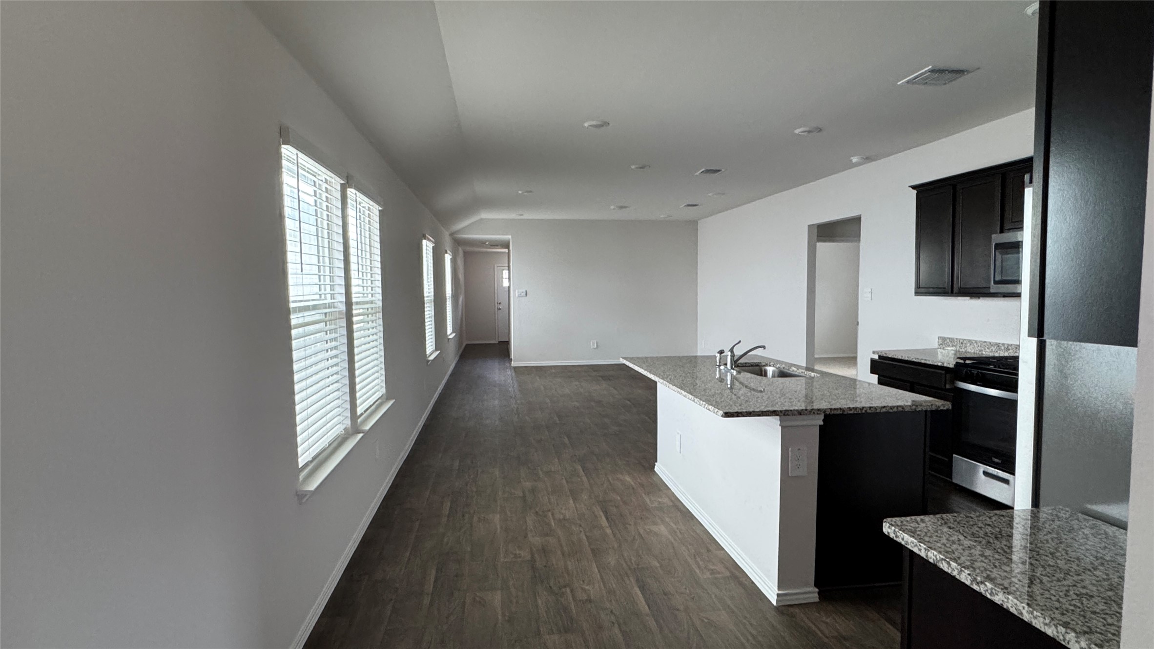 408 Frogmore Loop Kyle, TX 78640 - Photo 31 of 32 An open floorplan seamlessly connects the kitchen and living areas, highlighted by durable flooring and abundant natural light.