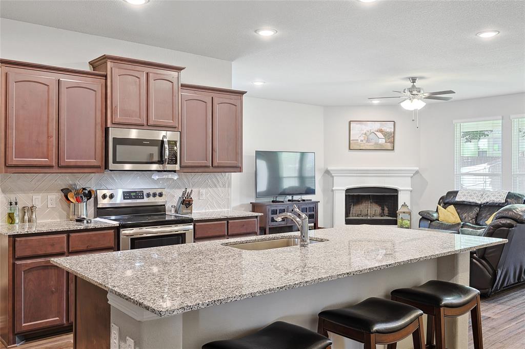 808 Feather Edge Drive Springtown, TX 76082 - Photo 12 of 40 a kitchen with a stove a sink and a refrigerator