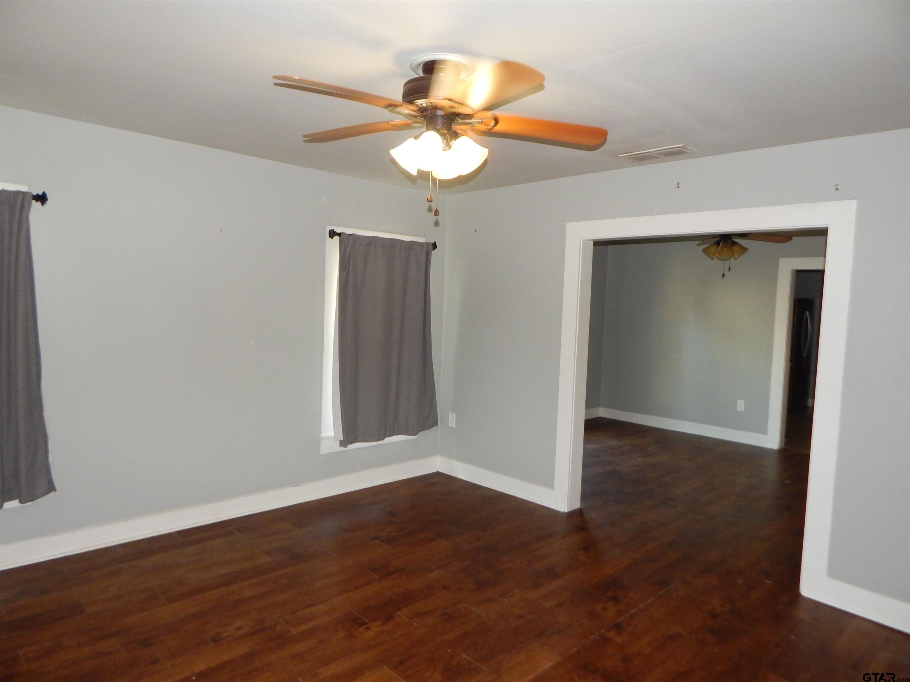 507 North Trinity Street Gilmer, TX 75644 - Photo 14 of 45 a view of an empty room with wooden floor and a chandelier