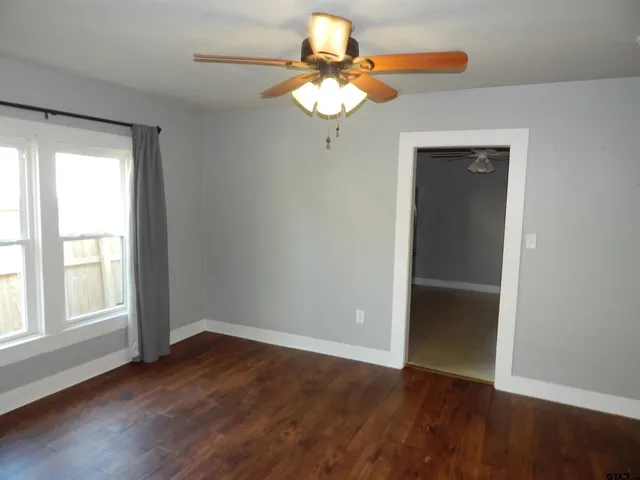 a view of a room with wooden floor and a window