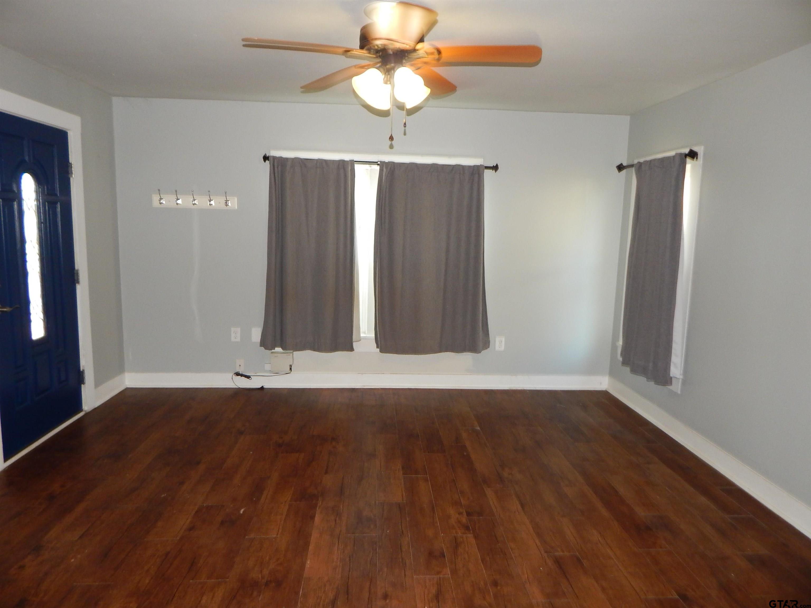 507 North Trinity Street Gilmer, TX 75644 - Photo 19 of 45 wooden floor in an empty room with a window