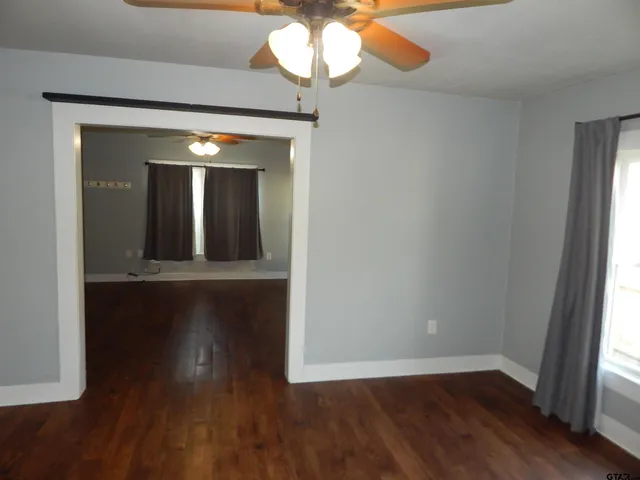 a view of a room with wooden floor and a large window
