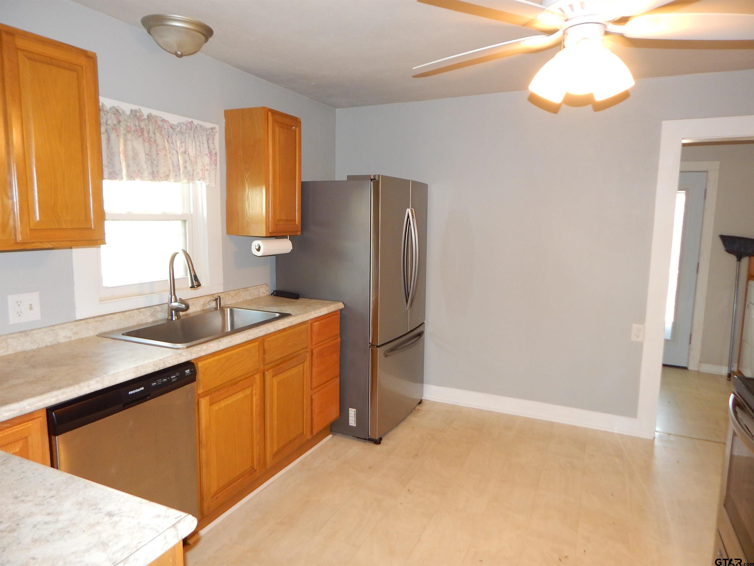 507 North Trinity Street Gilmer, TX 75644 - Photo 21 of 45 a kitchen with stainless steel appliances granite countertop a refrigerator and a sink