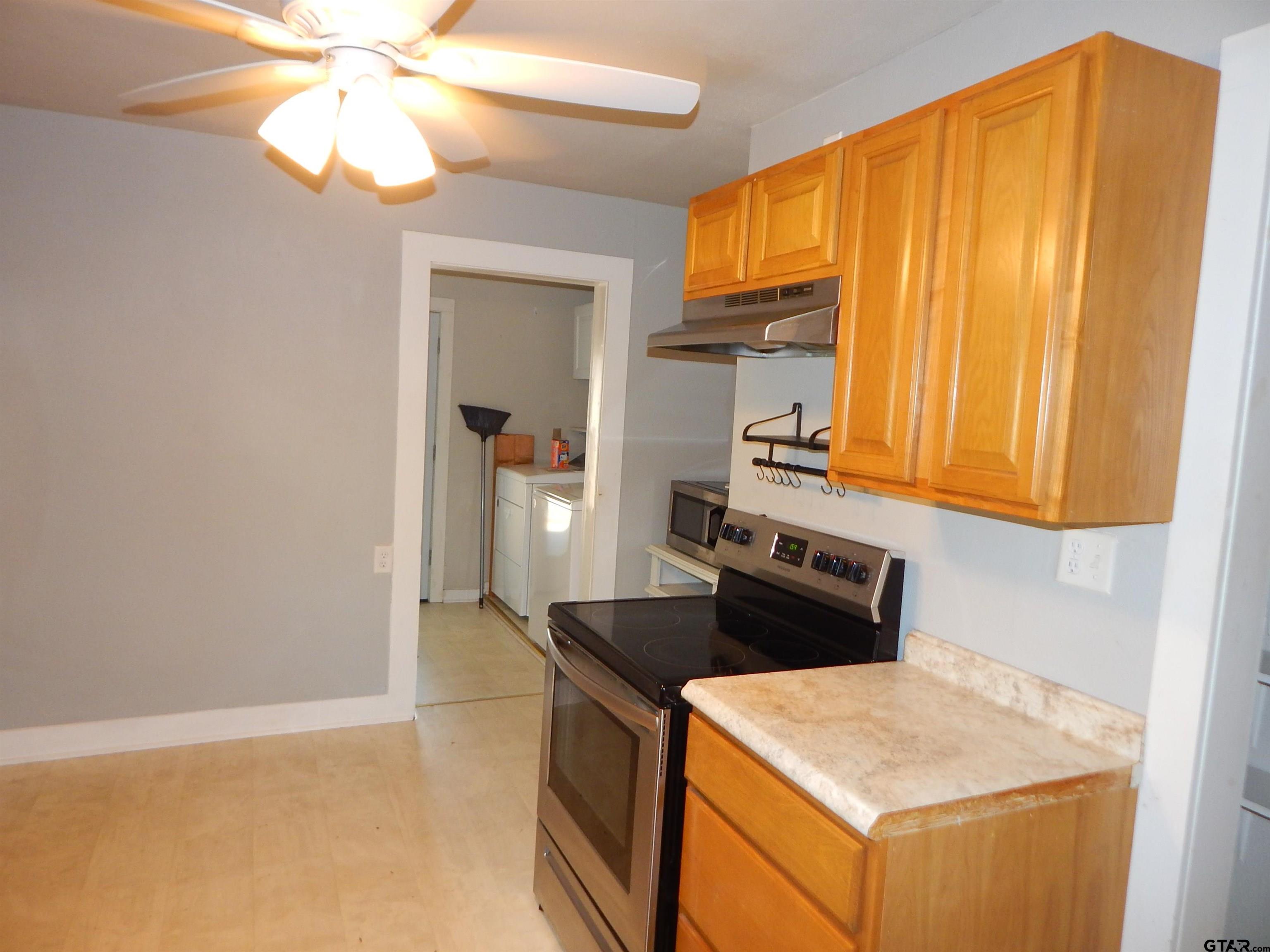 507 North Trinity Street Gilmer, TX 75644 - Photo 22 of 45 a kitchen with a stove and a refrigerator