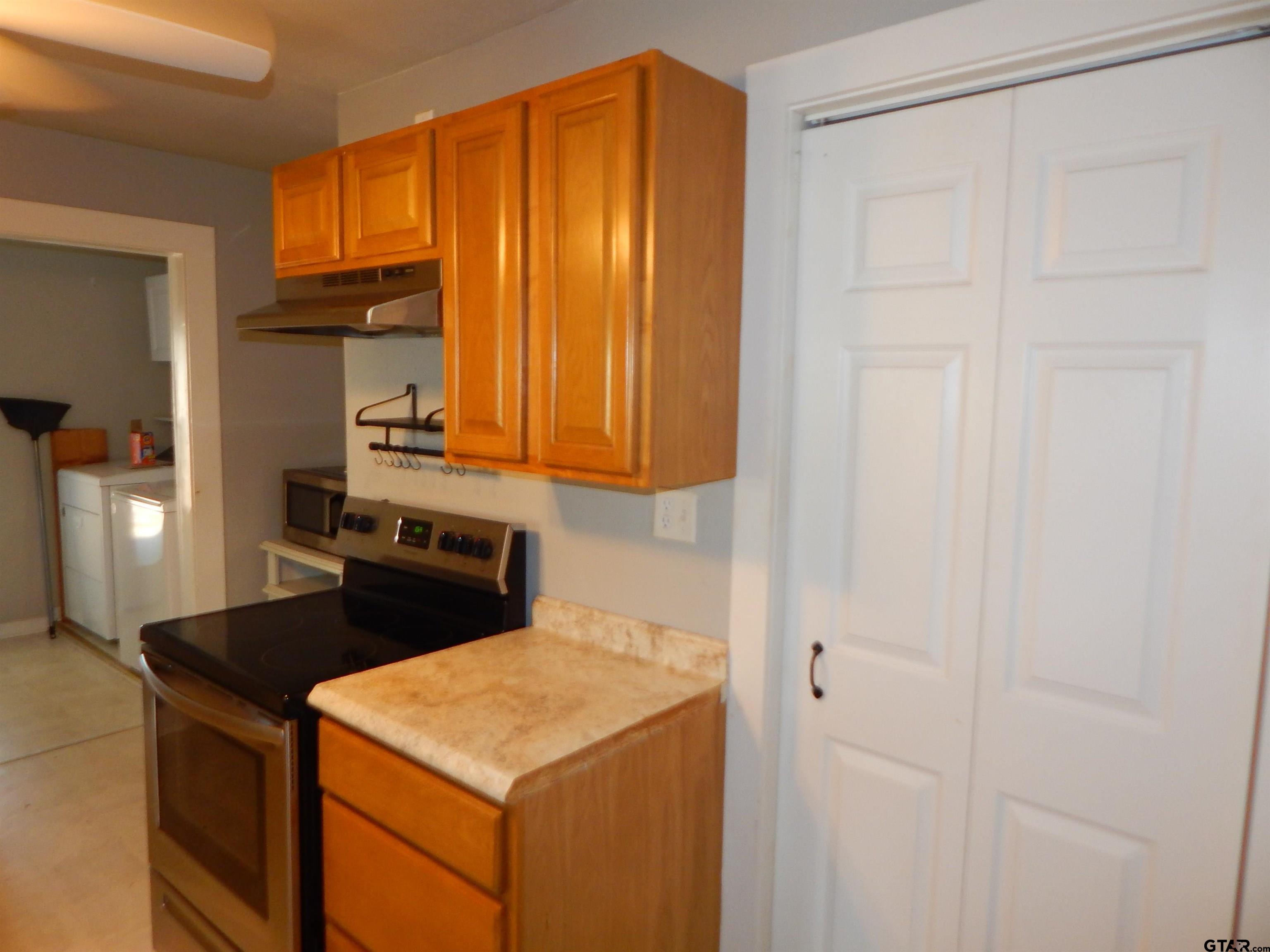 507 North Trinity Street Gilmer, TX 75644 - Photo 23 of 45 a kitchen with a stove and a refrigerator