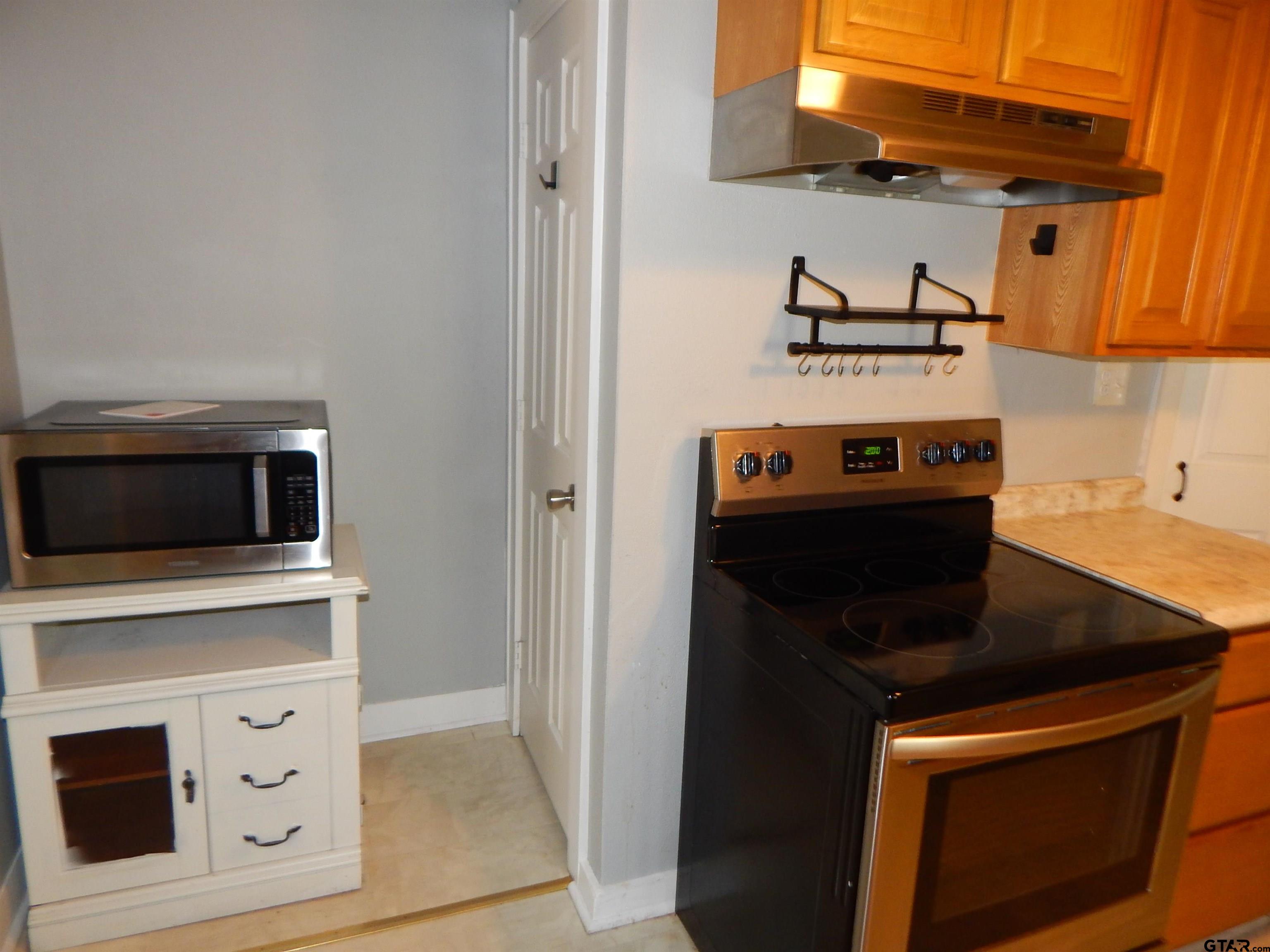 507 North Trinity Street Gilmer, TX 75644 - Photo 25 of 45 a kitchen with a stove and a microwave