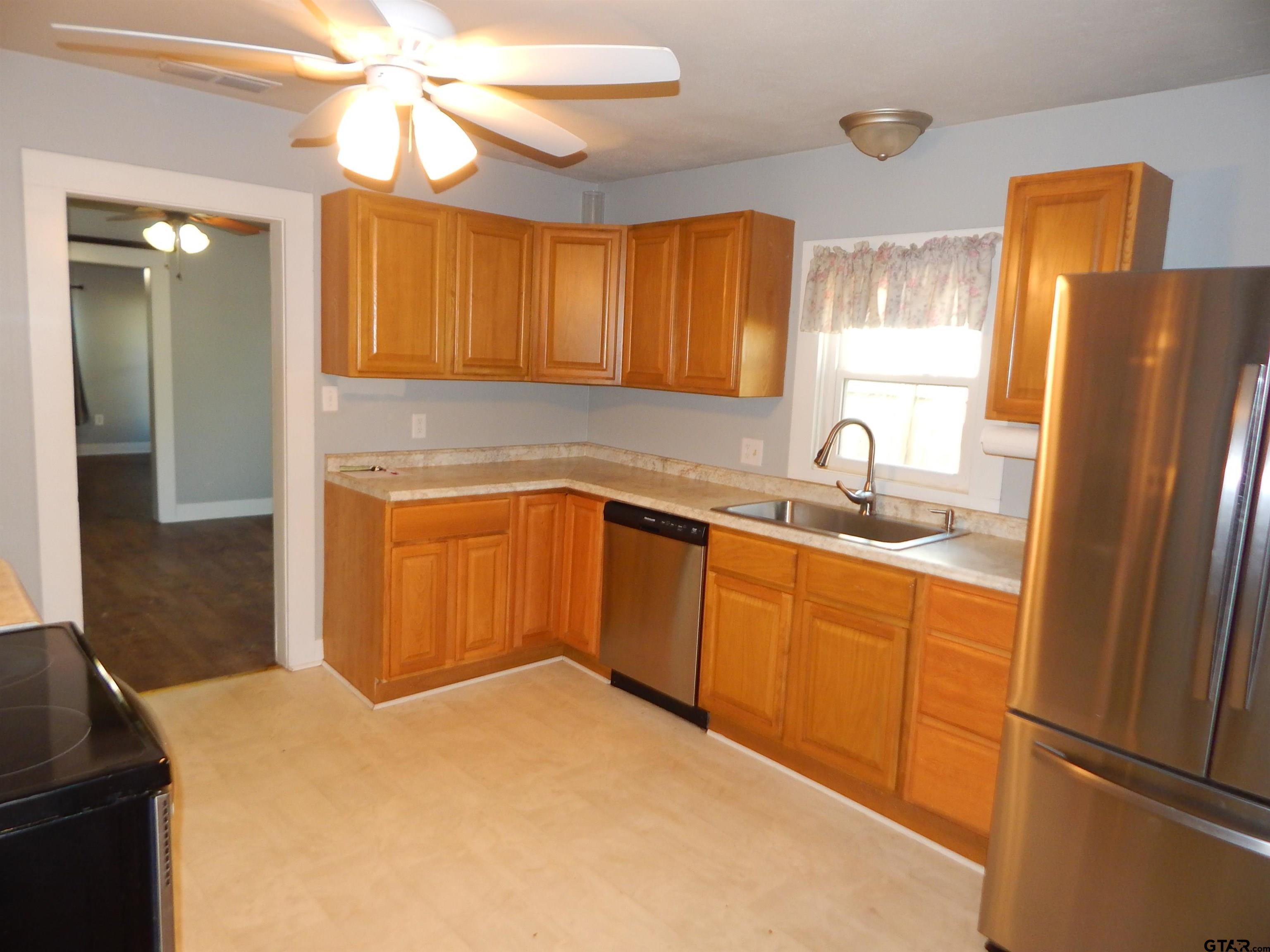 507 North Trinity Street Gilmer, TX 75644 - Photo 26 of 45 a kitchen with stainless steel appliances granite countertop a microwave a sink and a refrigerator