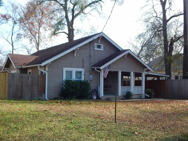 a view of a house with a yard and wooden fence