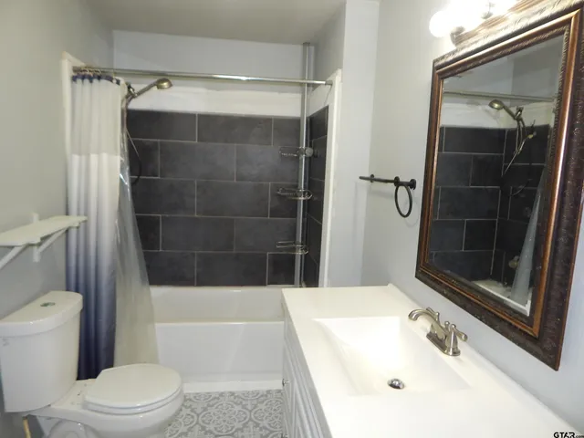 a bathroom with a tub a sink and a mirror