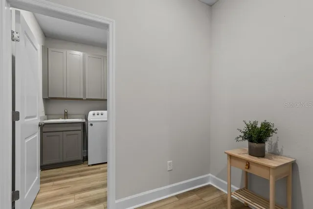 a view of cabinets with wooden floor and plant