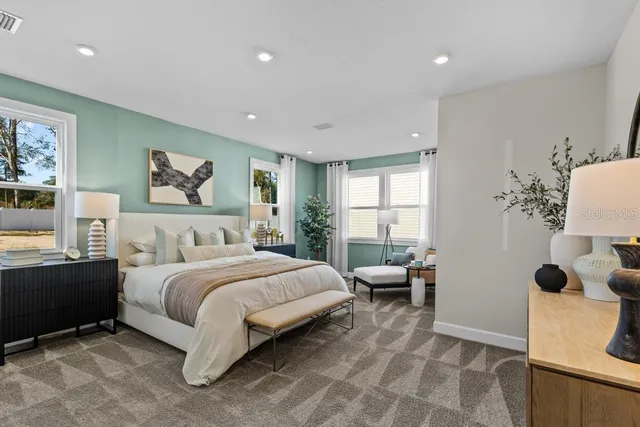 a bedroom with a large bed and a potted plant