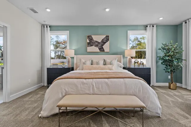 a bedroom with bed and a mirror on the dresser