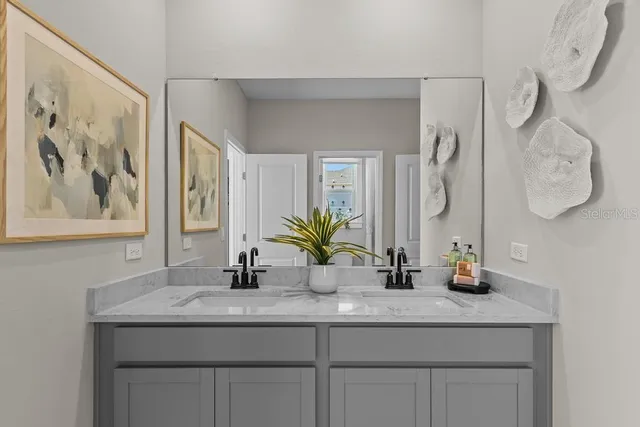 a bathroom with a granite countertop sink a mirror and vanity
