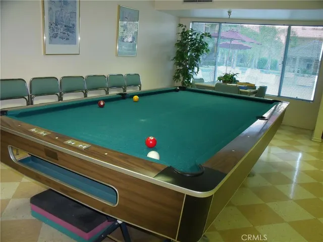 a room with pool table and windows