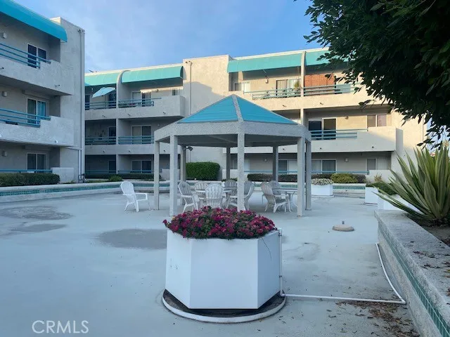 a view of a white house with table and chairs potted plants
