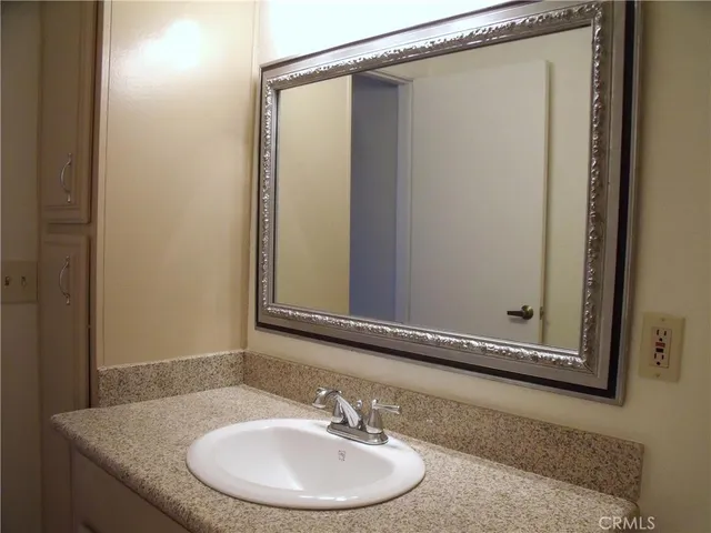 a bathroom with a granite countertop sink and a mirror