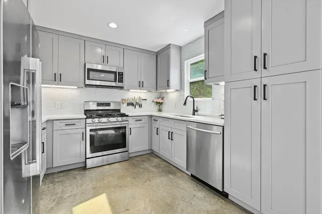 a kitchen with white cabinets and white appliances