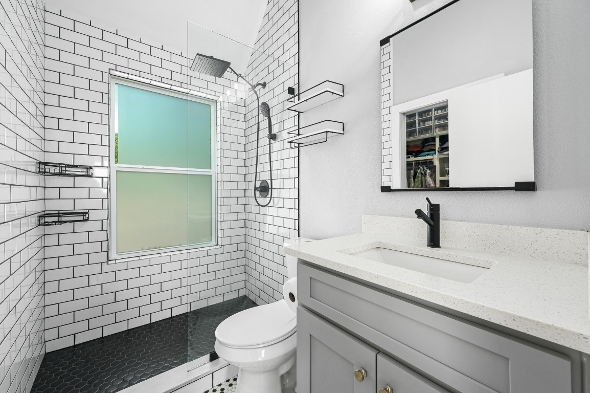 1210 Luna Street, Unit 2 Austin, TX 78721 - Photo 18 of 28 a bathroom with a sink a toilet and mirror