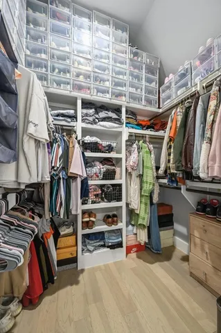 a view of walk in closet with clothes and shoes