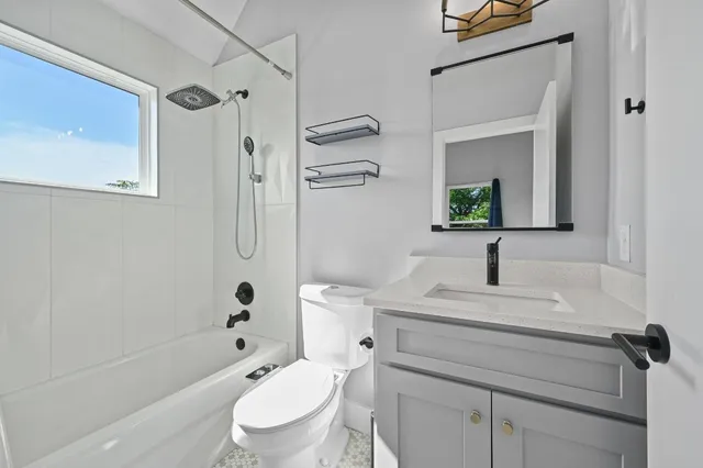 a bathroom with a granite countertop sink toilet a mirror a vanity and shower