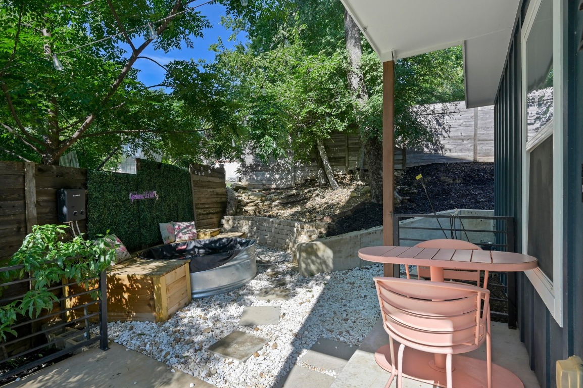 1210 Luna Street, Unit 2 Austin, TX 78721 - Photo 3 of 28 a view of a patio with table and chairs potted plants and large tree