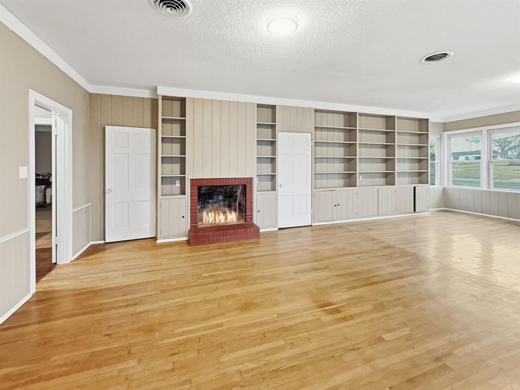 720 East Leslie Street Hamilton, TX 76531 - Photo 11 of 31 a view of an empty room with a fireplace and a window