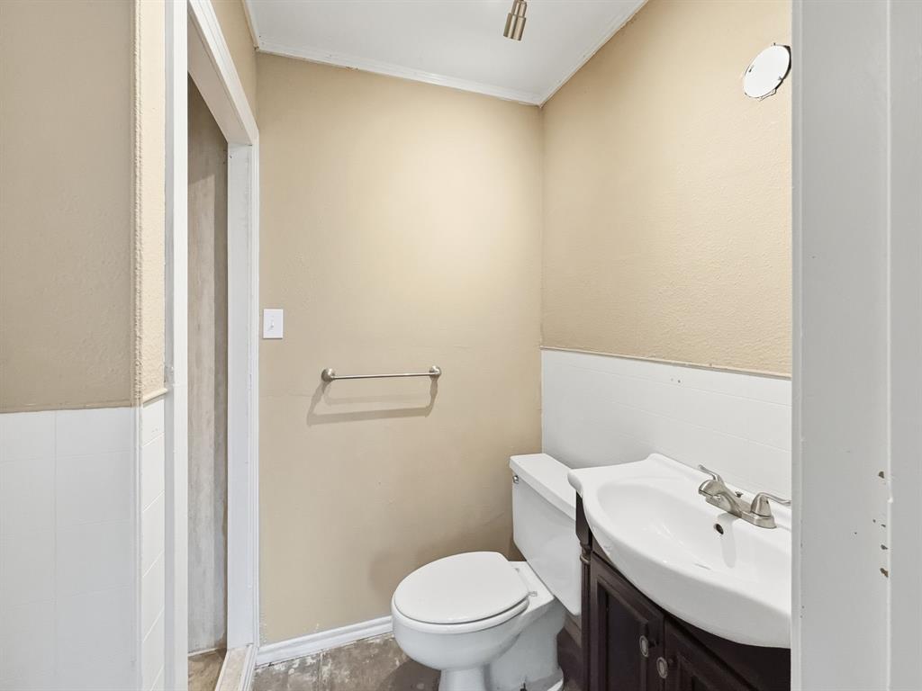 720 East Leslie Street Hamilton, TX 76531 - Photo 17 of 31 a bathroom with a sink a toilet and a mirror