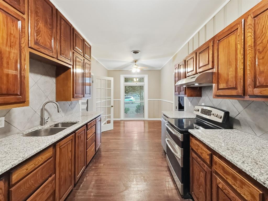 720 East Leslie Street Hamilton, TX 76531 - Photo 7 of 31 a kitchen with stainless steel appliances granite countertop a sink stove and cabinets
