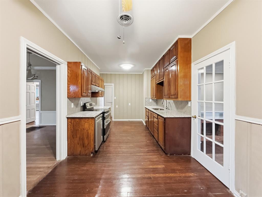 720 East Leslie Street Hamilton, TX 76531 - Photo 8 of 31 a large kitchen with kitchen island wooden floors and stainless steel appliances