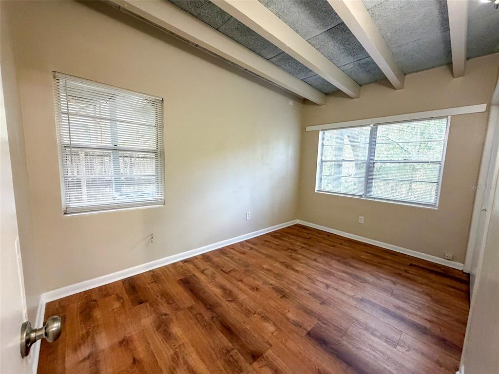 219 Northwest 3rd Avenue, Unit B Gainesville, FL 32601 - Photo 17 of 20 a view of empty room with wooden floor and fan