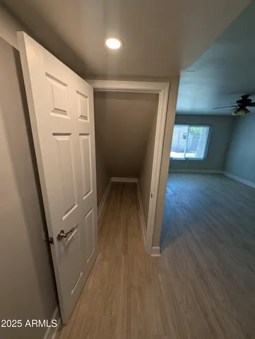 a view of a hallway with wooden floor and stairs