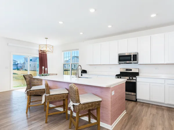a kitchen with a table chairs microwave and cabinets